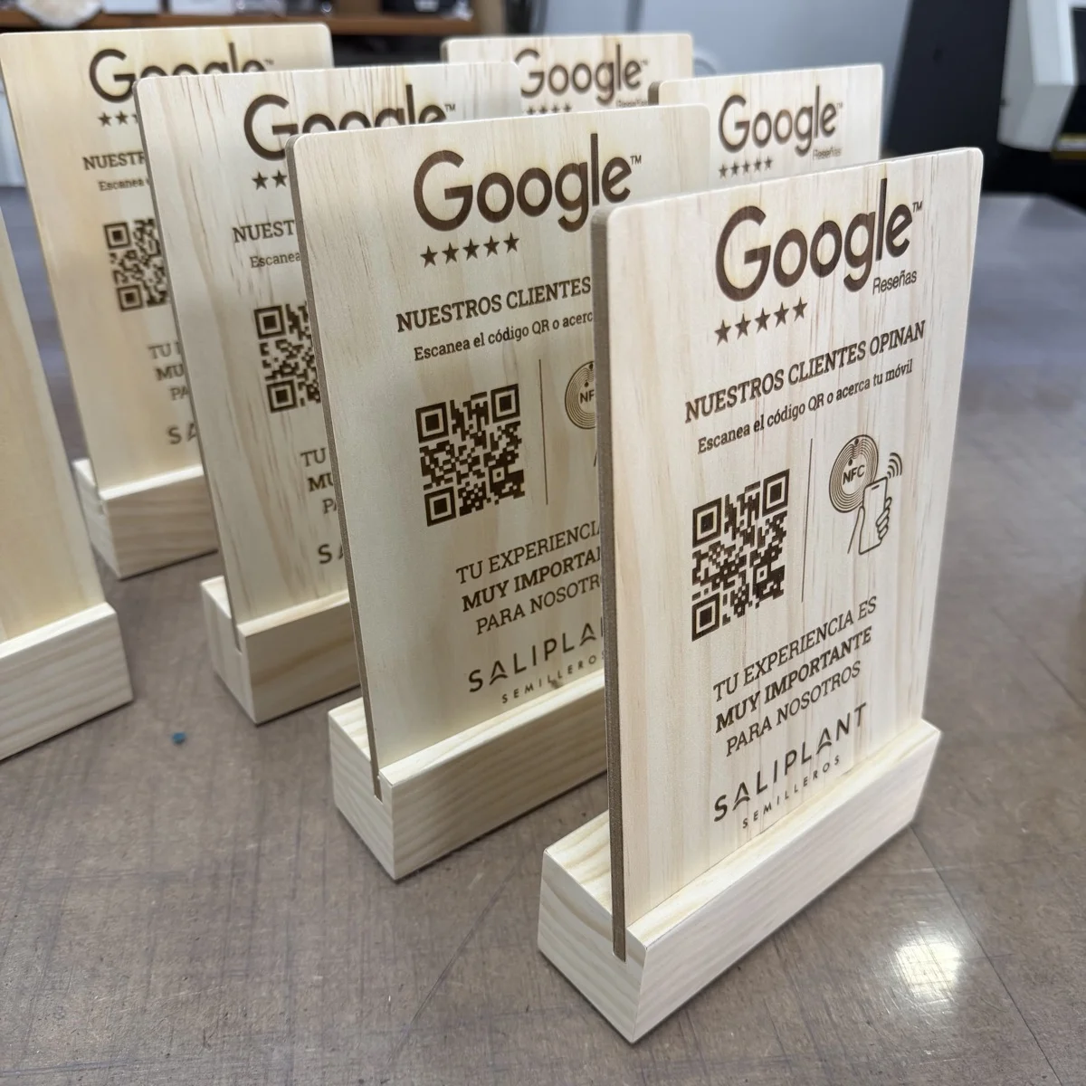 Varias placas de madera para Saliplant Semilleros, recién grabadas y con su peana