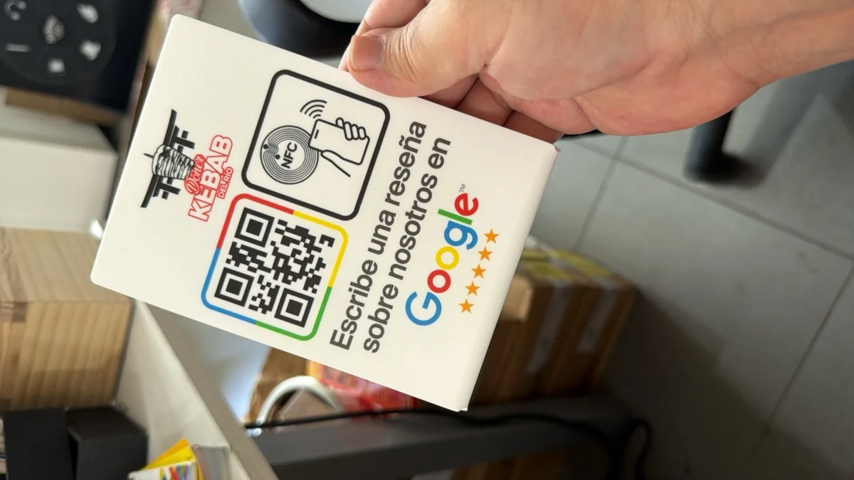 Placa de madera con QR y logotipo de Google, sujetada en el taller
