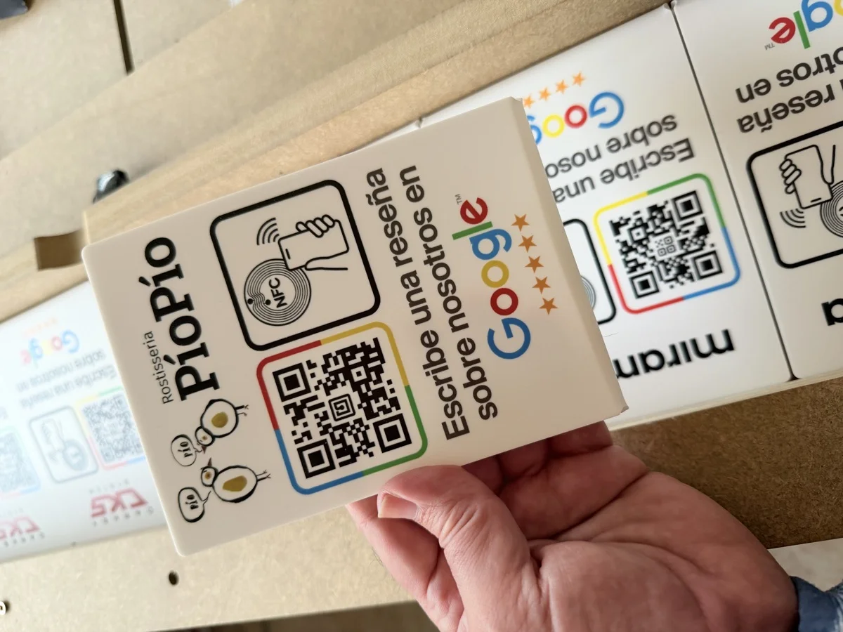 Placa de reseñas de Google para PioPío, recién impresa, con más placas detrás